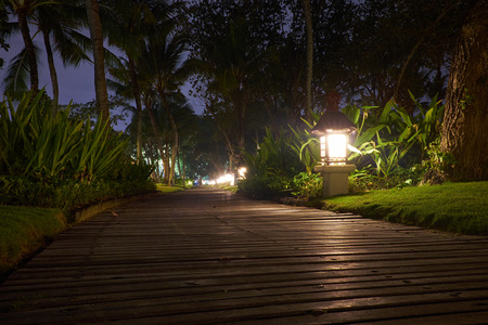 Wooden pathway in a tropical resort.  Night time.の写真素材