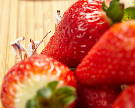 Small figures of painters paint strawberriesの写真素材
