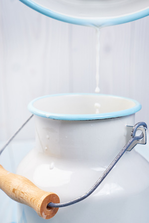pouring milk from a bucketの写真素材