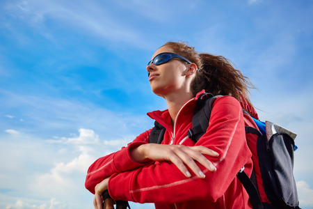 Lady tourist with a backpack standing on top of the mountain and enjoy the beautiful  hills of Tuscanyの写真素材