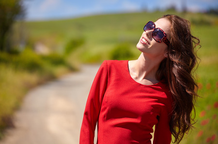 beautiful woman in red dress  in a poppy field in summerの写真素材
