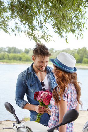 Portrait of romantic man giving flowers to womanの写真素材