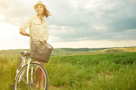beautiful vintage girl sitting next to bike, summer timeの写真素材