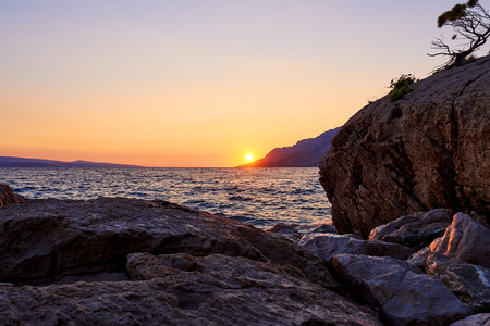 Rock island at golden sunset in Brela, Croatiaの写真素材
