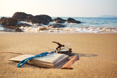panorama of tropical beach with old vintage sundial and notebookの写真素材