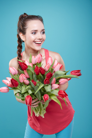 Young beautiful woman studio portrait with tulip flowersの写真素材