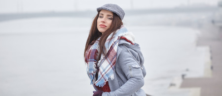 fashion woman walking outdoor against an city river landscapeの写真素材