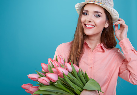 Young beautiful woman studio portrait with tulip flowersの写真素材