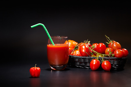 Glass of tomato juice with vegetables on black backgroundの写真素材