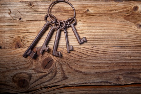 rusty medieval keys on worn out wood tableの写真素材
