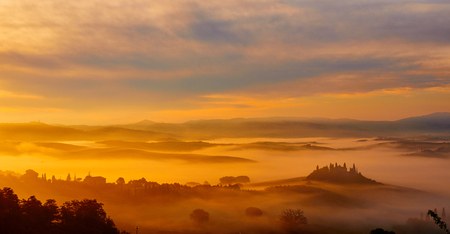 Beautiful view of green fields and meadows at sunset in Tuscanyの写真素材