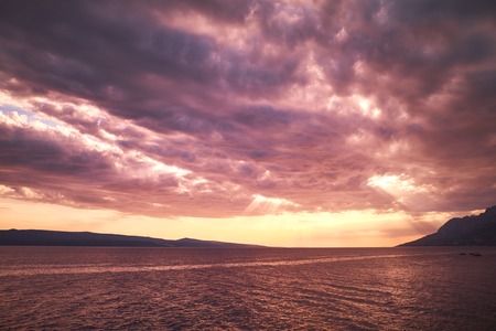 Rock island at sunset in small mediterranean town Brela , Croatia
