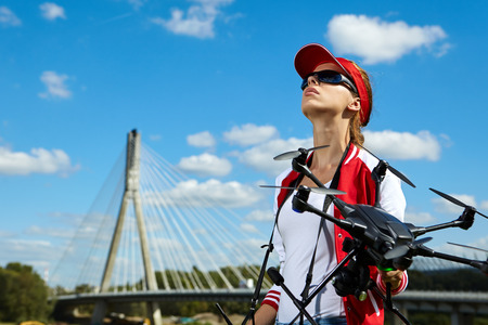 A woman is standing and holding drone