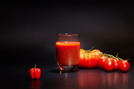 fresh organic tomatoes and tomato juice on black. the detox conceptの写真素材