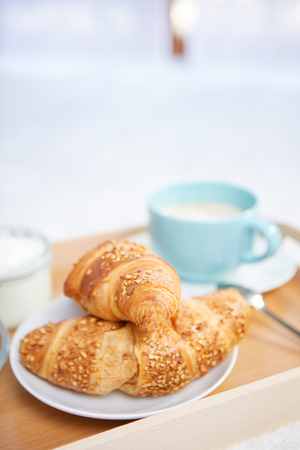 breakfast in bed with coffee and croissantsの写真素材