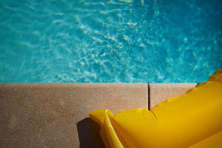 The mattress and hat lie on the edge of the pool. top viewの写真素材