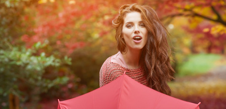 Portrait of an autumn woman over red and golden leavesの写真素材