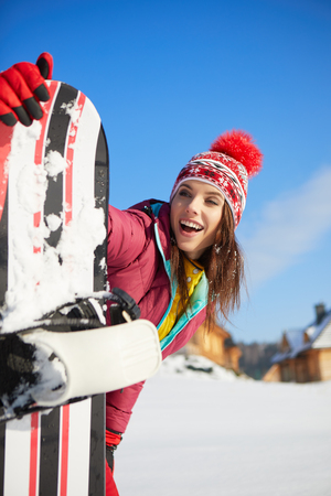 Sport woman  snowboarder on snow over blue skyの写真素材