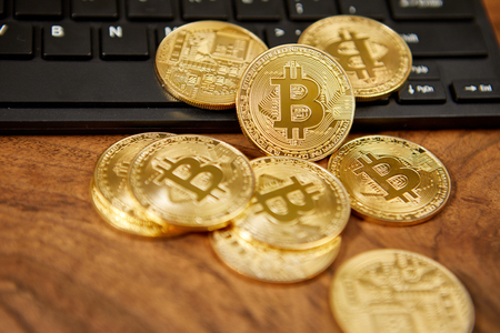 Golden bitcoins on a black computer keyboard の写真素材