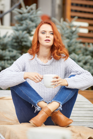Outdoors portrait of beautiful woman with red hair and smoky eyes makeupの写真素材