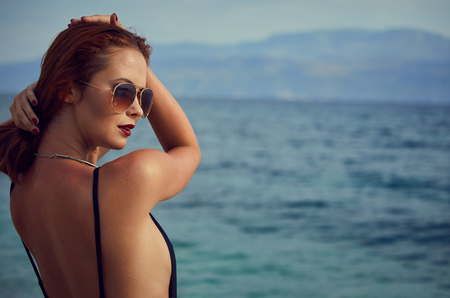 summer sunny portrait of pretty young sensual redhair woman posing in bikiniの写真素材