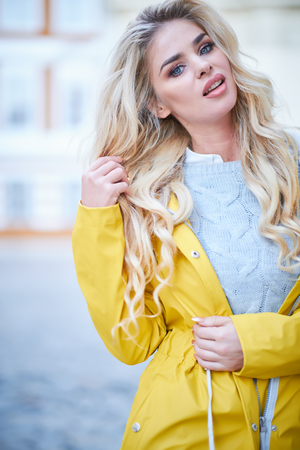 Blonde girl in a yellow raincoatの写真素材