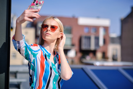 Happy young woman taking selfie on rootfopの写真素材
