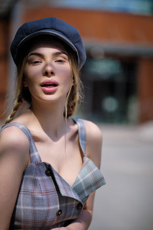Portrait of blonde girl with flyaway hair in the street backgroundの写真素材