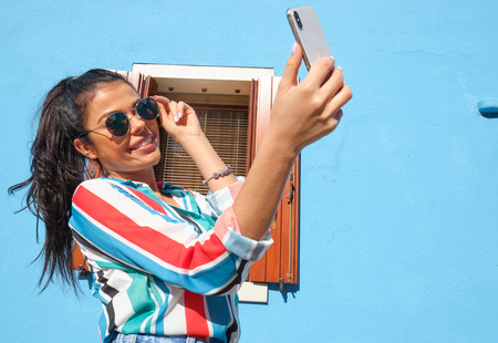 Pretty young woman in glasses making selfie