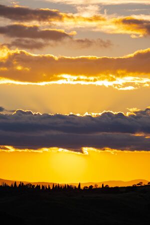 View of rolling countryside at sunset, Tuscany, Italyの写真素材