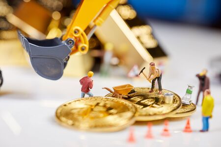 A little miner is digging on graphic card with golden coin. bitcoin mining and crypto currency concept.の写真素材