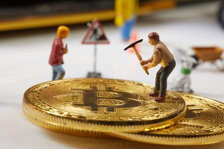 A little miner is digging on graphic card with golden coin. bitcoin mining and crypto currency concept.の写真素材