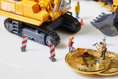 A little miner is digging on graphic card with golden coin. bitcoin mining and crypto currency concept.の写真素材