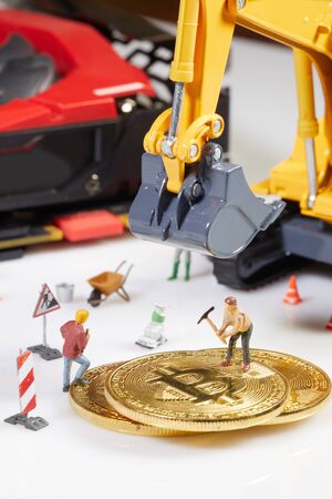 A little miner is digging on graphic card with golden coin. bitcoin mining and crypto currency concept.の写真素材