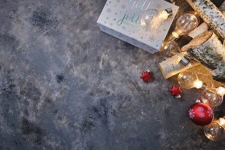 Christmas background with wood tree and decor. Top view with copy space and lighting bulb