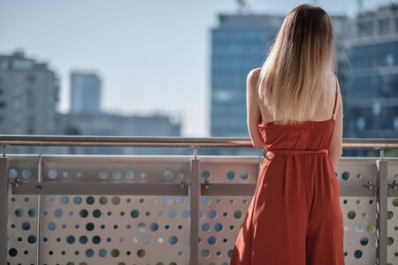 Woman relaxing on balcony. City landscape viewの写真素材