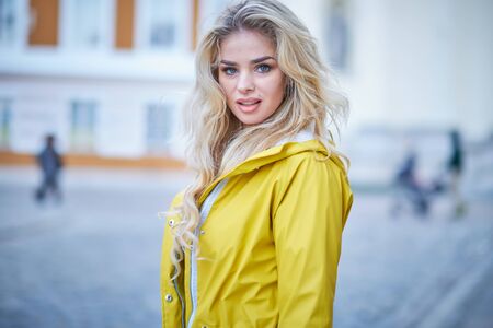 Spring girl walking in a yellow coatの写真素材
