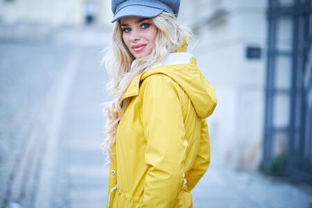 Spring girl walking in a yellow coatの写真素材