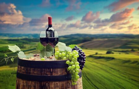 red wine bottle and wine glass on wodden barrelの写真素材