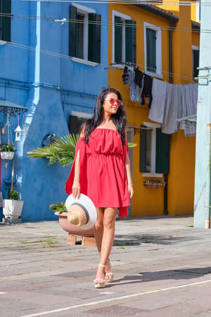 elegant, fashionable girl with glasse stay in the street, in a romantic Burano, Italyの写真素材
