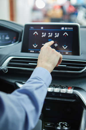 the driver controls the air conditioning in a modern electric carの写真素材