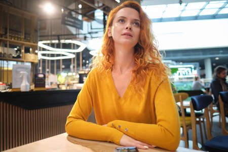 Portrait of woman sitting in cafe at morning and using smartphone. Shopping mall, after shoppingの写真素材