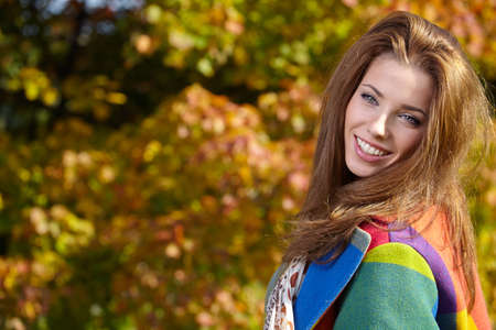 Beautiful elegant woman standing in a park in autumnの写真素材