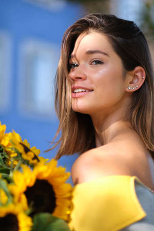 Young fashion woman with a bouquet of sunflowers in the cityの写真素材