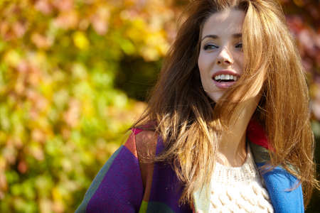 Beautiful elegant woman standing in a park in autumnの写真素材