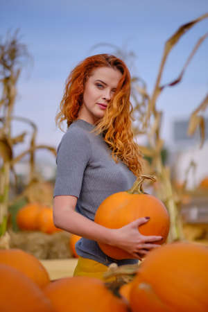 Autumn portrait of a beautiful woman with pumpkinsの写真素材