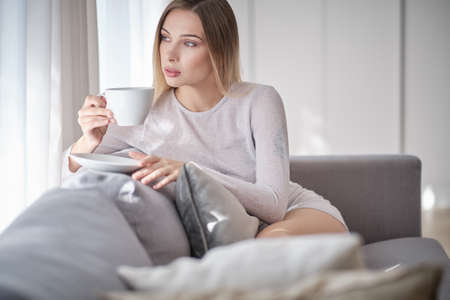 woman drinking morning coffee in her apartmentの写真素材
