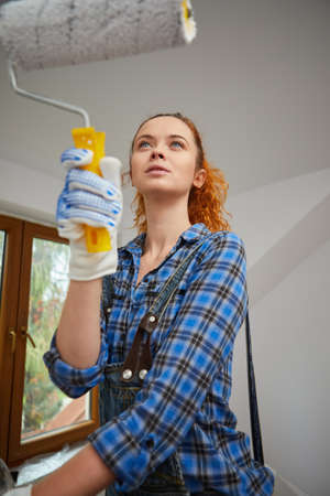A young woman is renovating the apartment. Painting wallsの写真素材