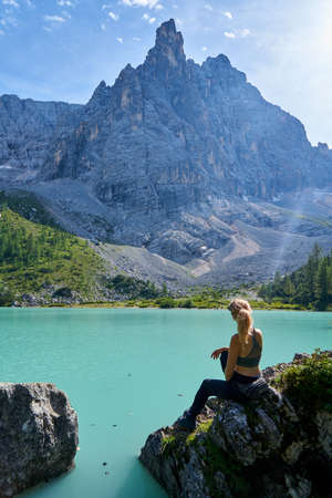 a woman is resting on the shore of a mountain lake. vanlifeの写真素材