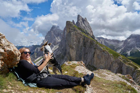 Young tourist walking the dog in the Dolomites mountainsの写真素材